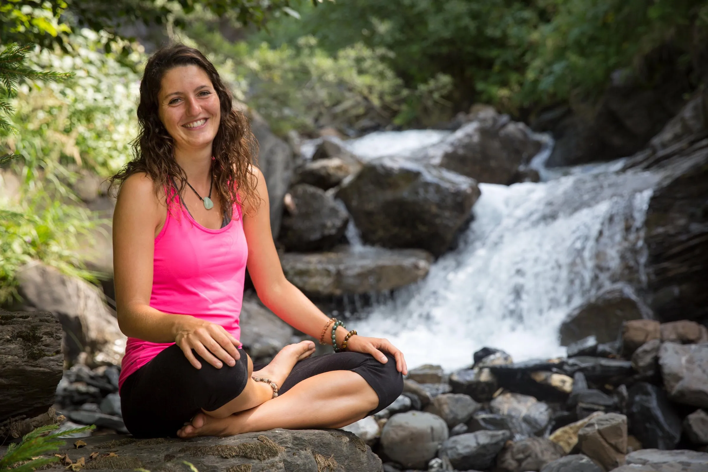 Evelyne Rey-Bellet assise au bord d'une cascade