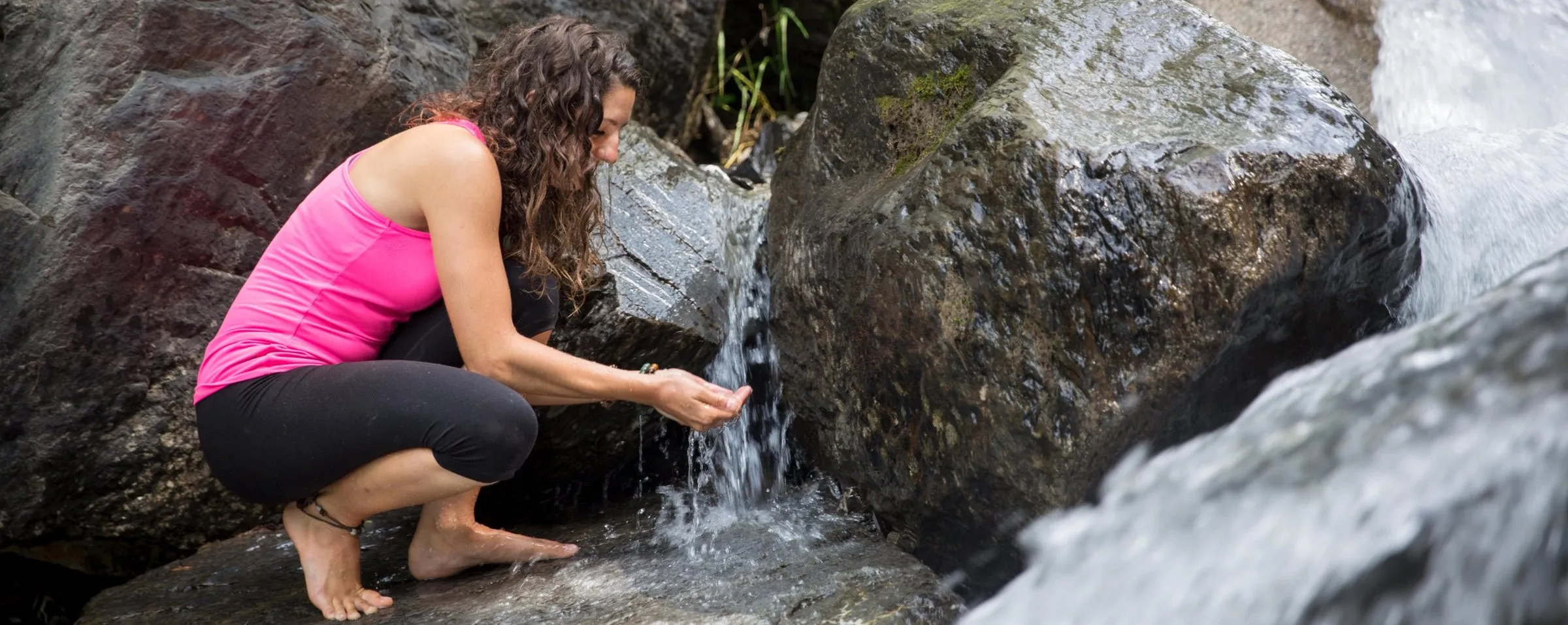 Evelyne recueille l'eau d'une source de montagne